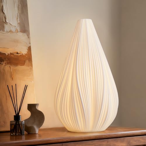 Fluted ceramic table lamp lit on wood console table