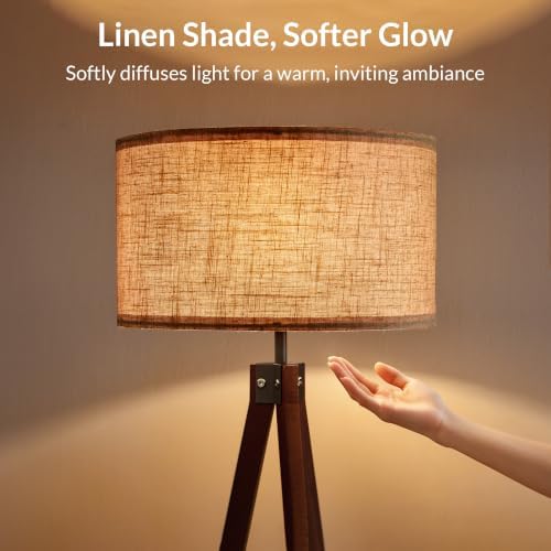 Walnut tripod floor lamp lit at night