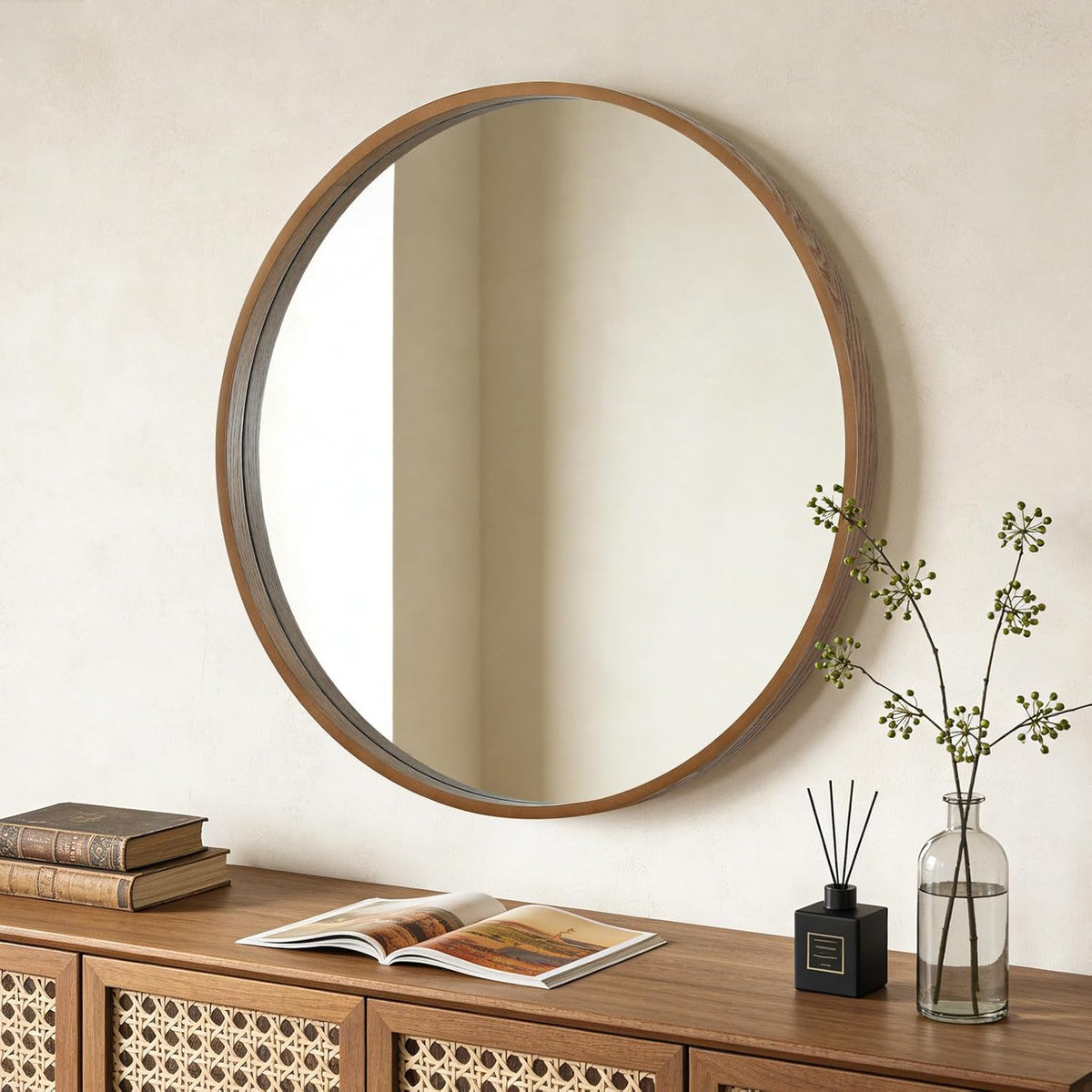 Round wood mirror above a console with rattan doors