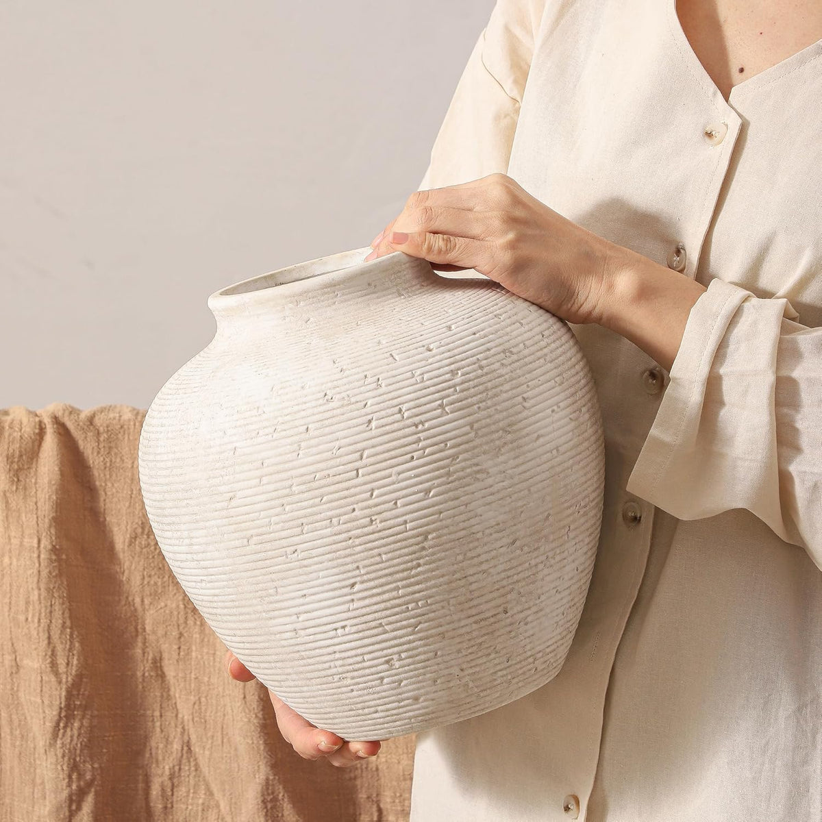 Large textured off-white ceramic moon vase held in hand