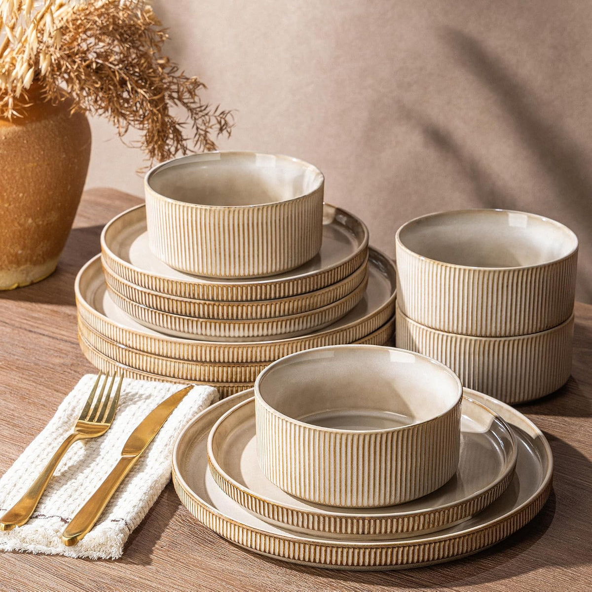 Ribbed sand stoneware dinnerware set stacked on a wood table