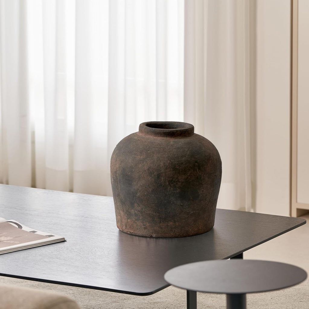 Weathered brown vase on a dining table in a bright room