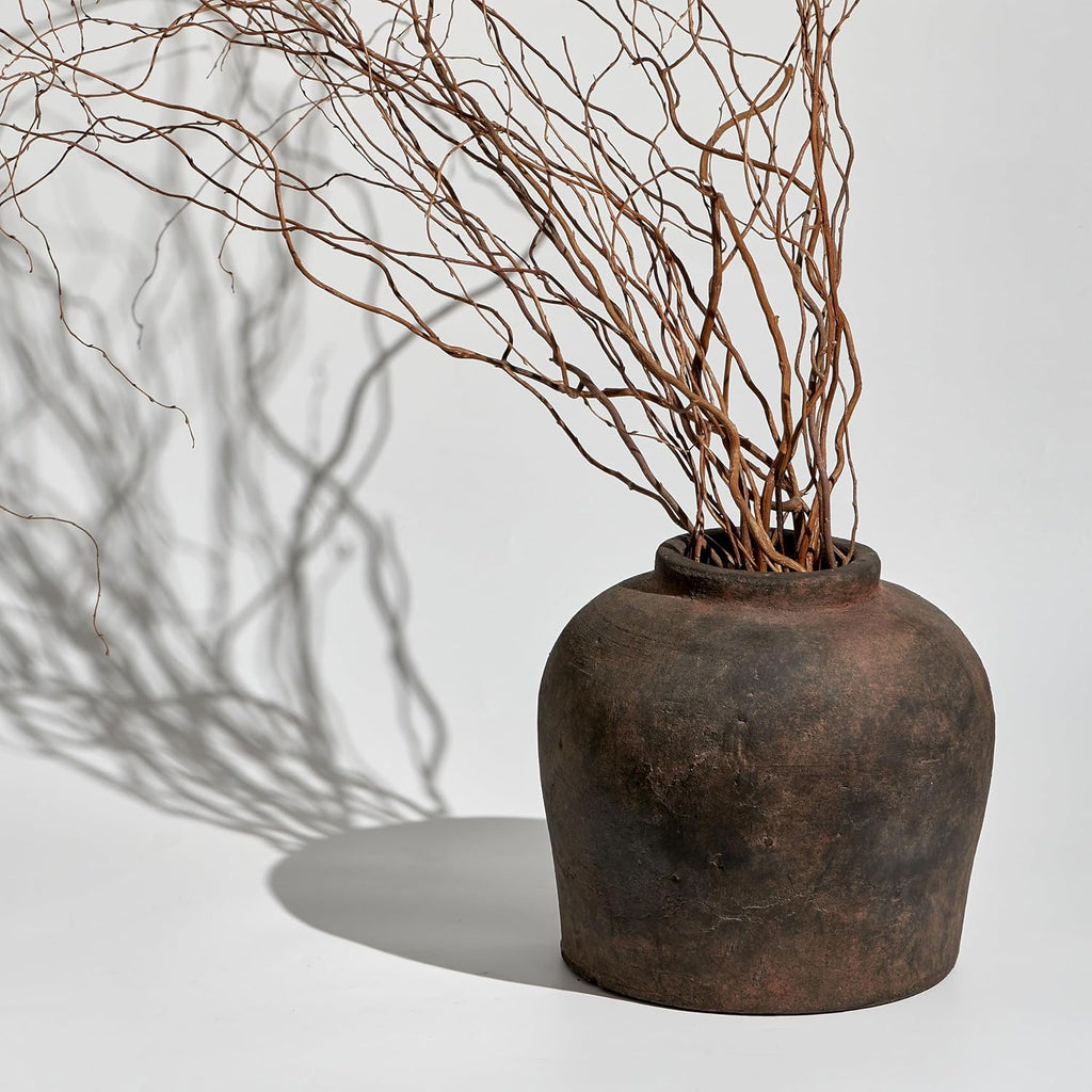Brown ceramic vessel styled with sculptural branches